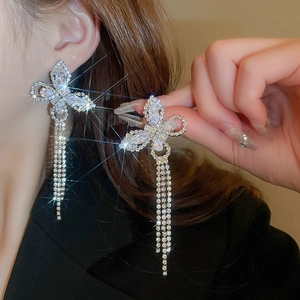 Detailed close-up of a silver butterfly earring with shimmering tassel and zircon stones