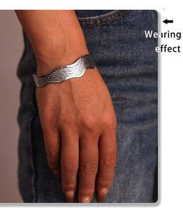 Close-up of wavy texture and hammered finish on a minimalist stainless steel cuff bracelet