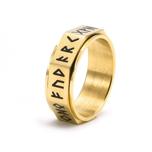 Close-up of golden Viking rune spinner ring with brushed texture and engraved symbols