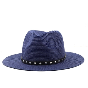 Detail of navy straw fedora hat with a black leather band and silver rivet studs