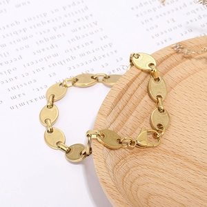 Detail of gold coffee bean link bracelet with sturdy lobster clasp on wooden tray