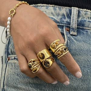Gold bohemian ring set with tiger eye stones and pearl bracelet on hand