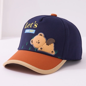 Detail of kids baseball cap featuring cartoon bear patch and navy orange color block