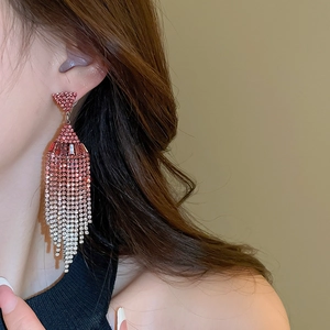Detail of pink gradient tassel earrings with rhinestones shown on model for fashion look