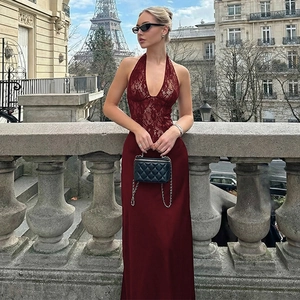 Detail of burgundy lace halter neck dress with satin skirt against a Paris city background