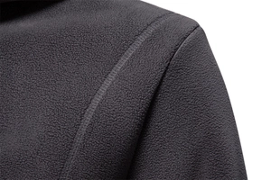 Macro detail of dark grey fleece fabric showing reinforced shoulder stitching and texture