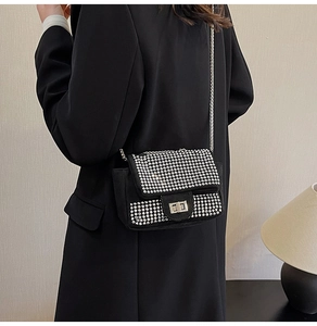 Close-up of a black velvet handbag with sparkling silver rhinestones and metal chain