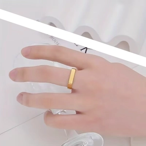 Elegant gold titanium ring shown on finger holding a glass for minimalist lifestyle