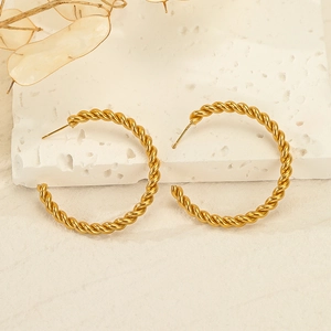 Chic twisted gold-plated stainless steel hoop earrings on a minimalist stone background