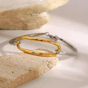 Detail of two-tone oval link bracelet with gold and silver finish on natural stone