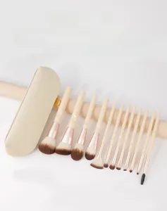 Dettaglio di 12 pennelli da trucco professionali con ghiere oro rosa e borsa beige