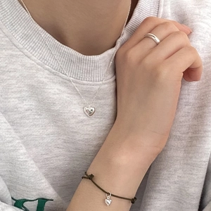Lifestyle shot of 925 sterling silver heart necklace bracelet and ring set on grey hoodie