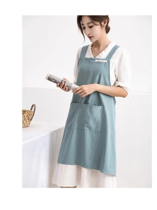 Detail of light blue linen apron showing large front pockets and minimalist label