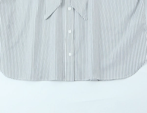 Detail of striped poplin shirt showing white buttons and curved hemline tailoring