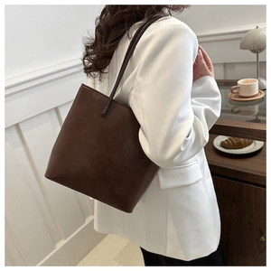 Close-up of deep brown matte leather tote bag shown in a professional commute setting
