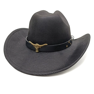 Detail of black cowboy hat featuring a gold bull head buckle and vintage metal rivets