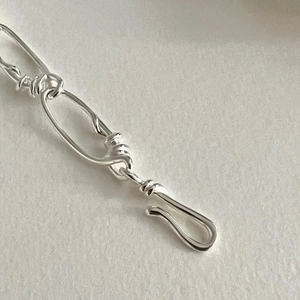 Macro detail of the S925 sterling silver chain bracelet showing link texture and buckle