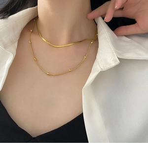 Double-layered gold titanium necklace featuring a minimalist flat snake chain and bead detail