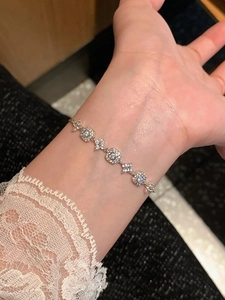 Detailed view of silver-tone flower bracelet with pavé cubic zirconia on lace sleeve