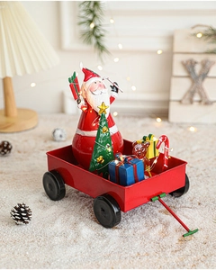 Détail d'un chariot de Noël rouge avec Père Noël, sapin et guirlande lumineuse LED