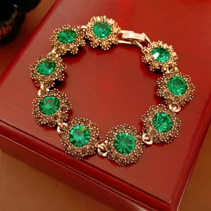 Vintage gold sunflower bracelet with green crystals displayed on a wooden jewelry box