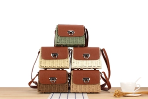 Detail of multi-colored woven crossbody bags with leather flaps in stack layout