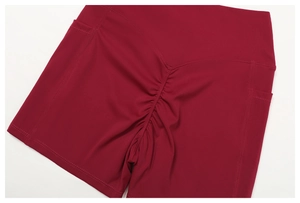 Dettaglio degli shorts da yoga a vita alta con design arricciato e tasche laterali