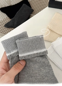 Close-up of elastic ribbed cuff on grey cotton crew socks showing high stretch flexibility