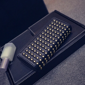 Vista dettagliata della pochette in pelle nera con borchie metalliche dorate e cerniera