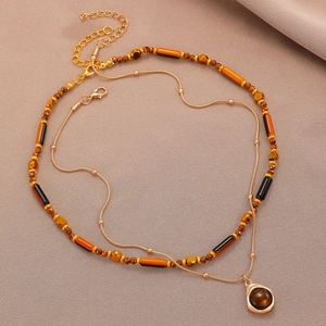 Detail of double-layer vintage necklace with brown beads and teardrop gemstone pendant