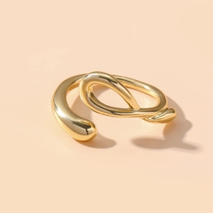 Detailansicht eines goldenen Rings mit fließenden Wellenlinien und Hochglanz-Finish
