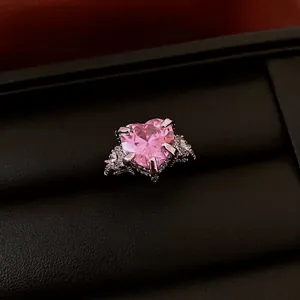 Eleganter herzförmiger Ring mit rosa Zirkonia und Tropfenakzenten in schwarzer Box