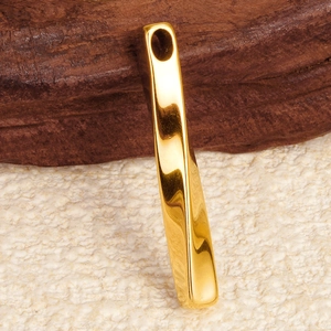 Macro shot of rectangular gold 304 stainless steel bar pendant on a wooden background