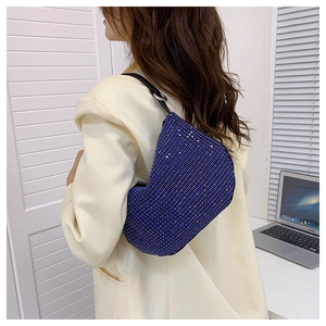 Blue rhinestone shoulder bag styled on model with white blazer in a lifestyle setting