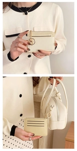 Close-up of beige textured coin purse with gold hardware and matching handbag accessory