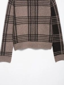 Detail of classic plaid knit cardigan with brown checkered pattern and ribbed hem
