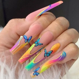 Detailed close-up of long gradient press-on nails with blue butterfly charms and glossy finish