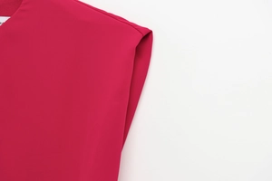 Detail view of magenta sleeveless romper showing stitching and EU size tag on fabric