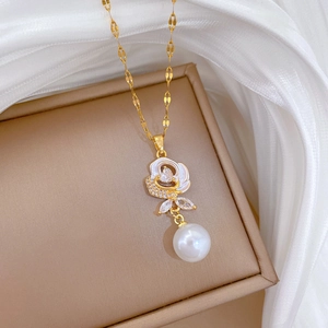 Detail of gold floral necklace with white rose pendant, crystals and dangling pearl