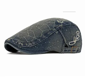 Detail of vintage blue denim beret featuring quilted texture and letter embroidery