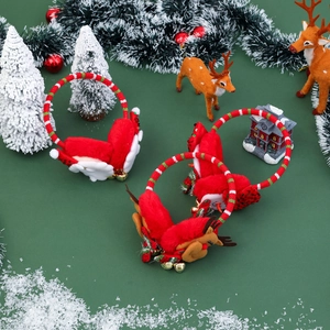 Plush Christmas earmuffs with reindeer, snowman and angel wing decorations on green background