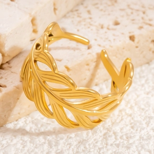 Luxurious gold feather open ring in stainless steel displayed on a natural stone base