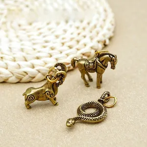 Détail de pendentifs du zodiaque en laiton vieilli représentant chèvre cheval et serpent