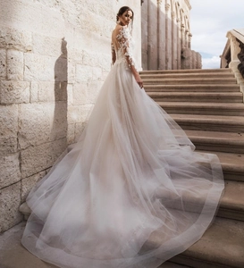 Detail of elegant lace bodice and sheer long sleeves on a white mermaid bridal gown