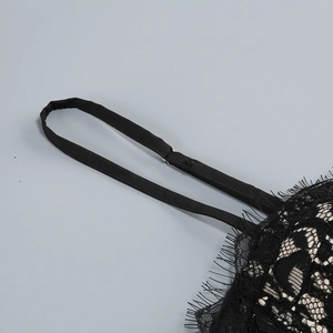 Dettaglio ravvicinato del pizzo nero delicato e delle spalline regolabili del vestito