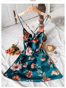 Detail of floral satin nightgown with silk texture and elegant thin straps on wood hanger