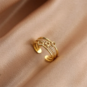 Detail of gold multilayer open ring with zircon heart and star on champagne satin