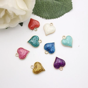 Flat lay of colorful heart charms with glitter enamel finish and gold metal frames