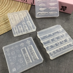 Silicone nail art molds featuring swan wings, hearts and gears on a grey background