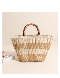 Detail of hand-woven straw tote with bamboo handle and elegant striped pattern